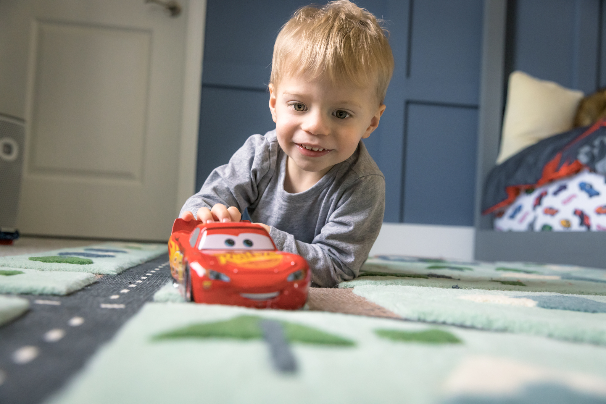 Little boy showing off his car collection during our in-home lifestyle family photography session in Woodridge, IL