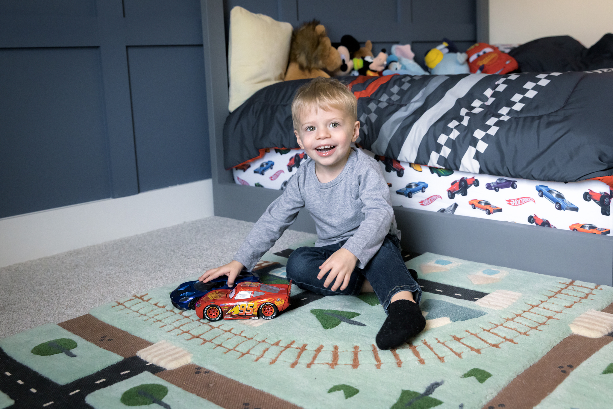 Little boy showing off his car collection during our in-home lifestyle family photography session in Woodridge, IL