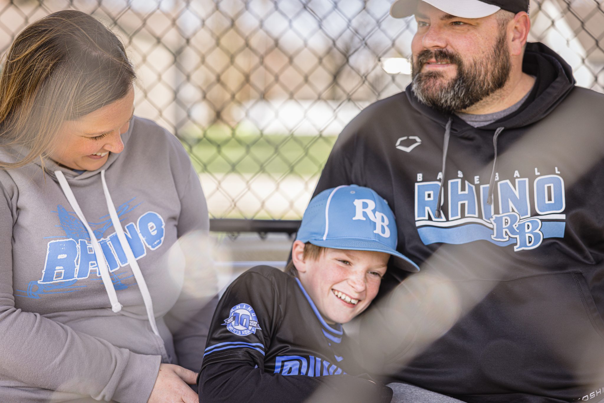 Mom, dad and son having a good laugh in the dug out at Channahon Pony baseball fields in Channahon, IL