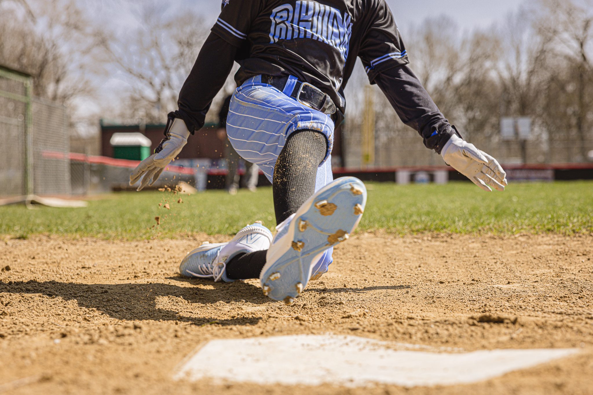 Boy in baseball uniform sliding into home plate at Channahon Pony Baseball Fields in Channahon, IL