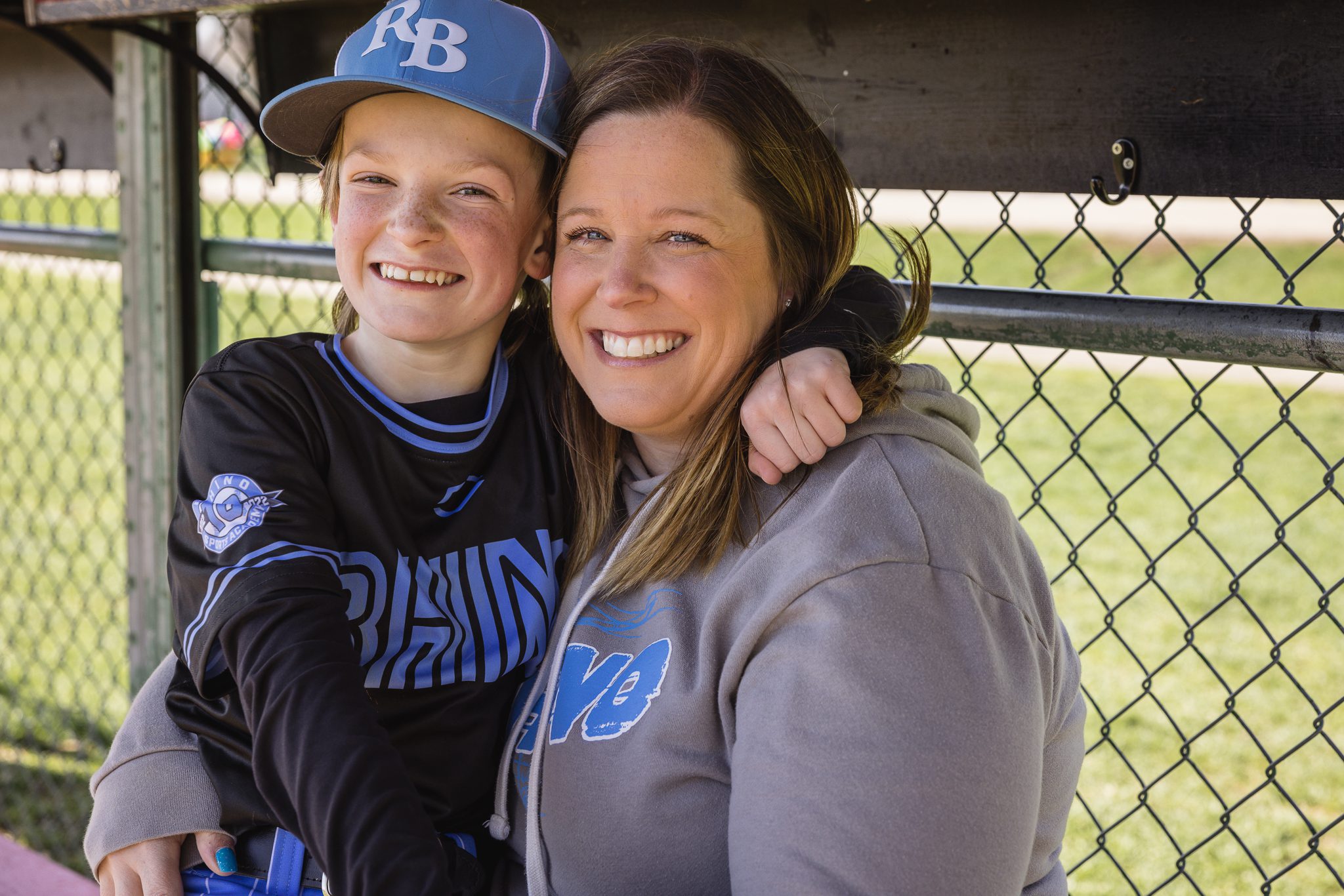 boy in baseball uniform hugging mom in dugout at Channahon Pony Baseball Fields in Channahon, IL
