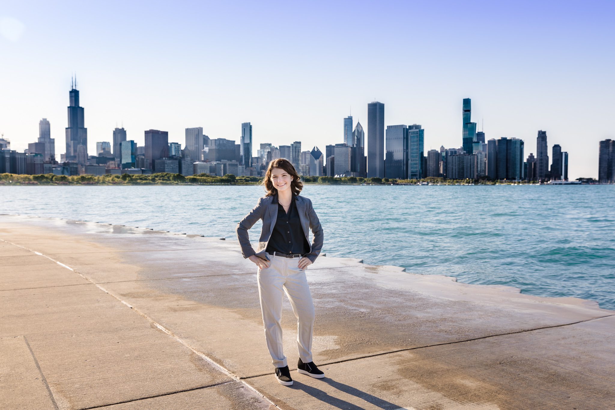 Teenage female posing and smiling for the camera with the skyline of Chicago in the background. Photo taken during her graduating senior session.