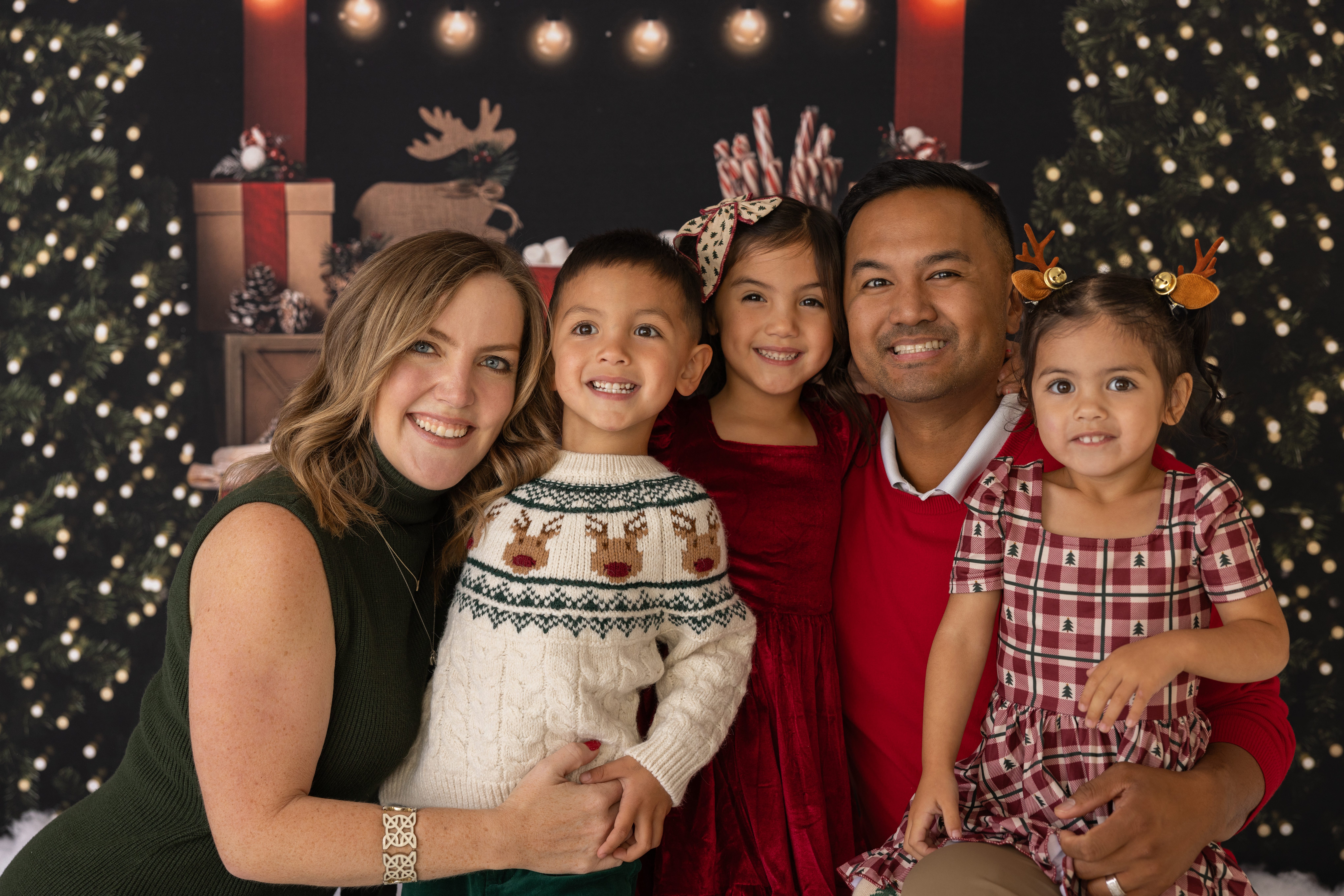 Mom and dad with three young kids all face to face and smiling at the camera. Photo taken during a family holiday mini session in Warrenville, IL