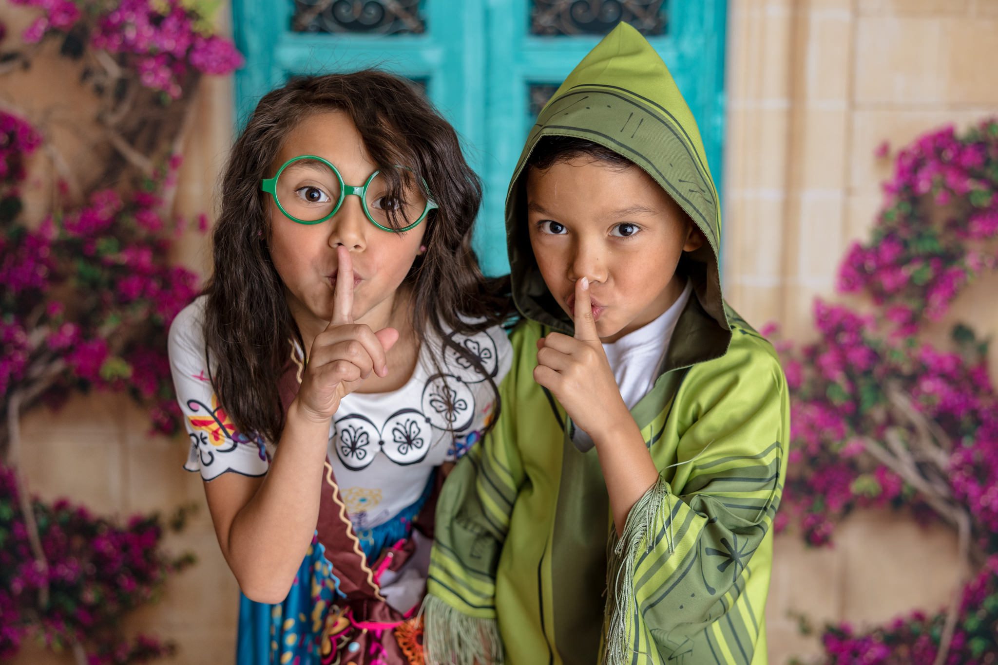 Brother and sister dressed as characters from Encanto and making a shhh face. Photo taken during a mini session in Warrenville, IL