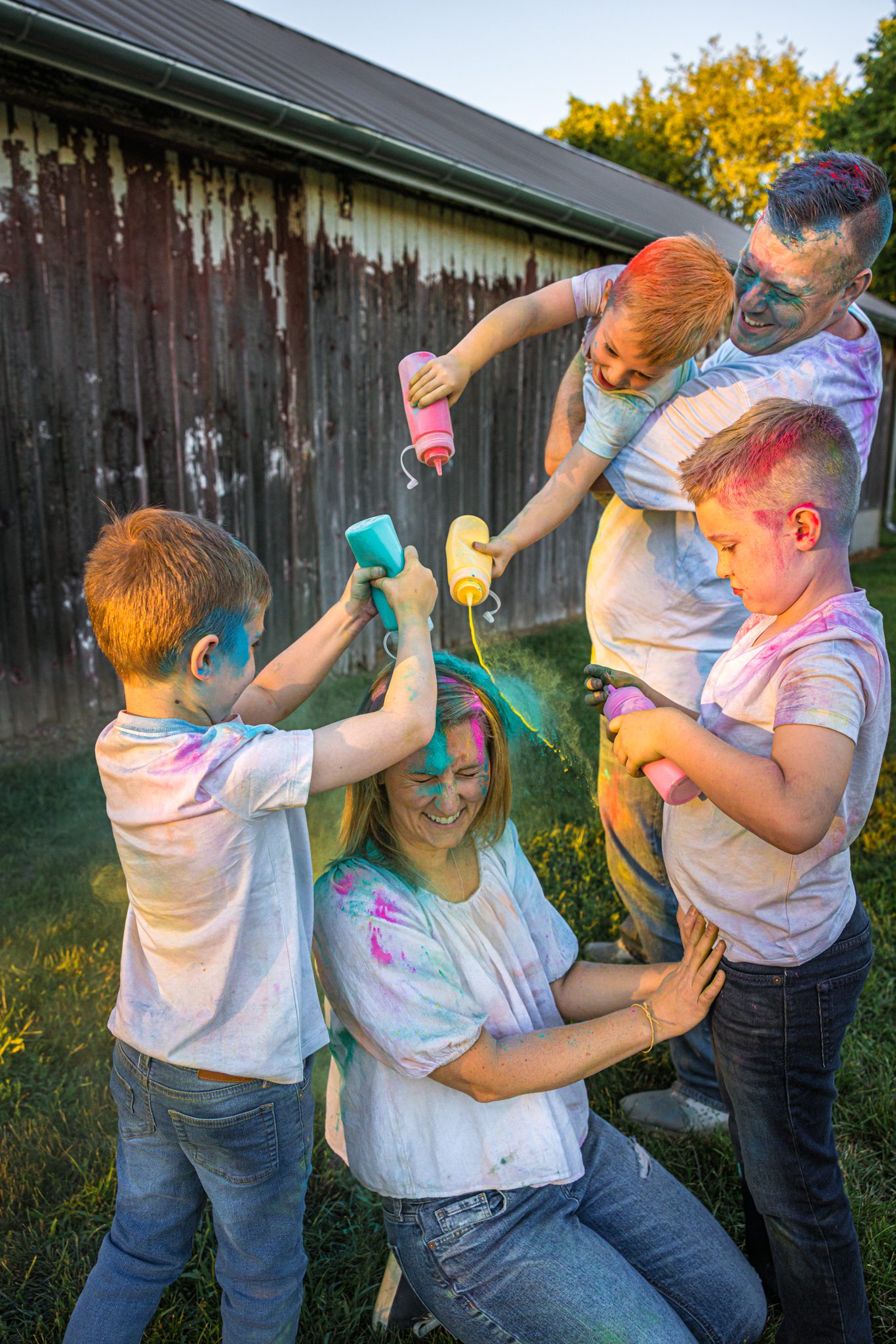 Family pouring holi powder on top of mom.