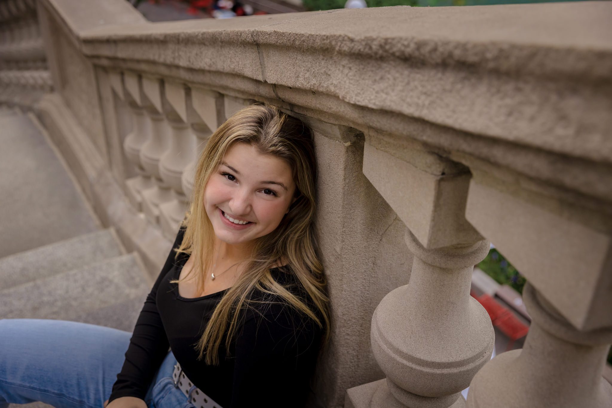 Teenage girl sitting on stair and leaning up against the railing. Photo taken on the riverwalk in downtown Chicago